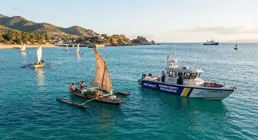 Pirogue à voile et vedette de sécurité maritime dans une baie de Madagascar